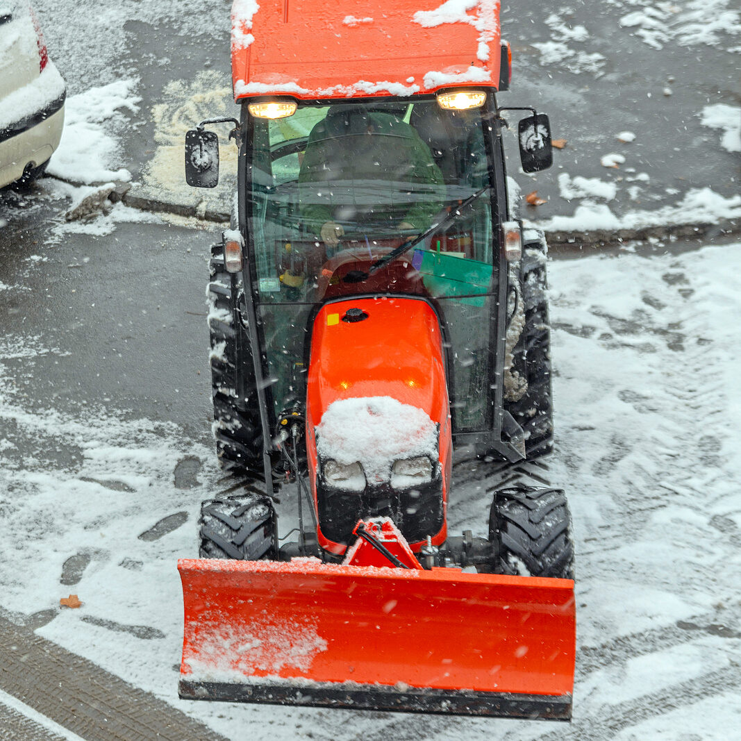 Snow Plow Tractor Vehicle at Street Winter Weather